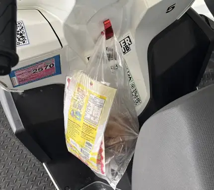 some snacks hanging on the honda click 160 bag hook