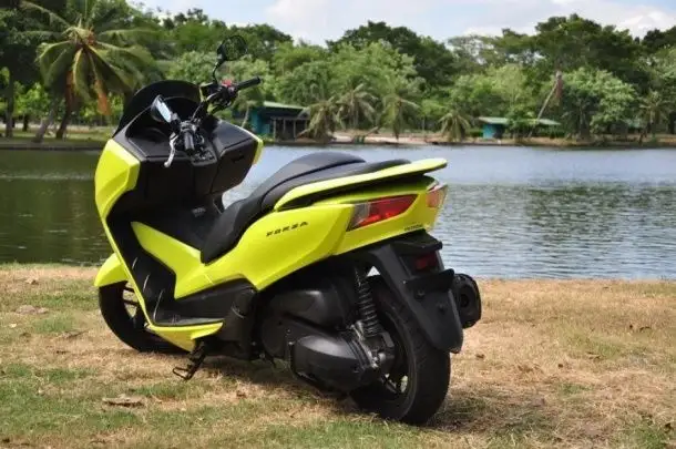 honda forza parked by a lake
