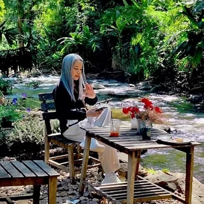 女士在 Mitbury 咖啡馆喝咖啡，描绘了骑着租摩托车爬完沙孟山路后的平静环境