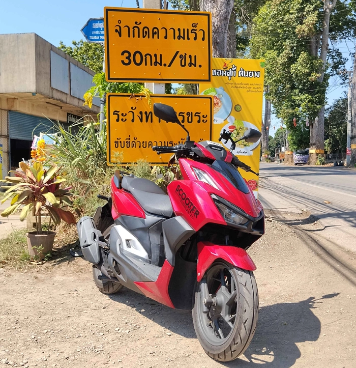 a red honda click 160 scooter on the famous big tree road in saraphi chiang mai