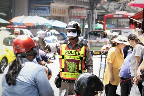 a thai policeman stopping traffic in chiang mai